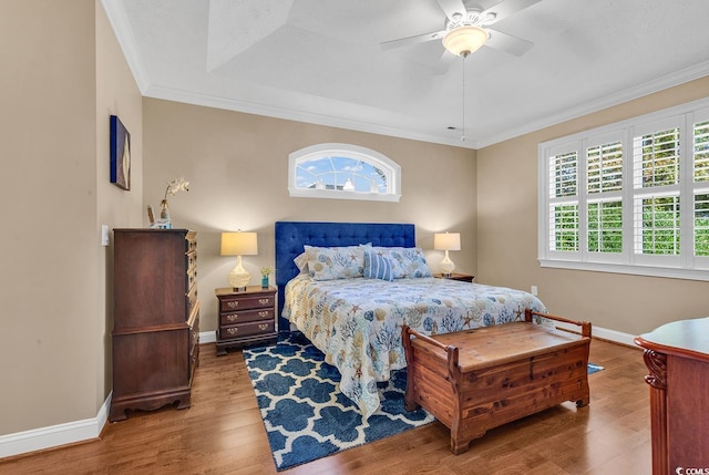 bedroom featuring hardwood / wood-style flooring, ceiling fan, and crown molding