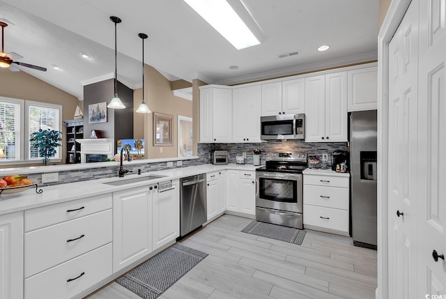 kitchen featuring white cabinetry, sink, ceiling fan, stainless steel appliances, and vaulted ceiling