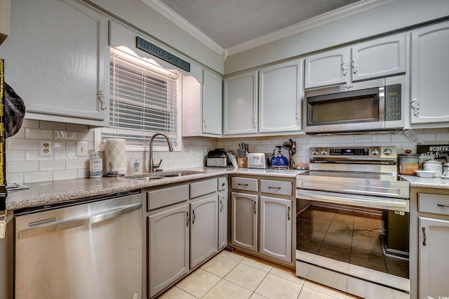 kitchen featuring sink, stainless steel appliances, crown molding, decorative backsplash, and light tile patterned floors