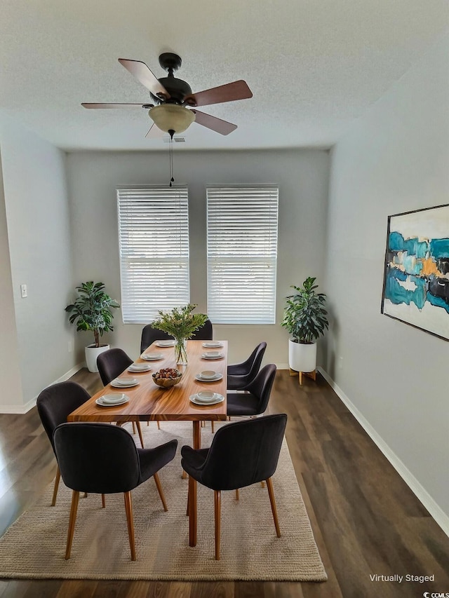 dining room with a textured ceiling, ceiling fan, and dark wood-type flooring