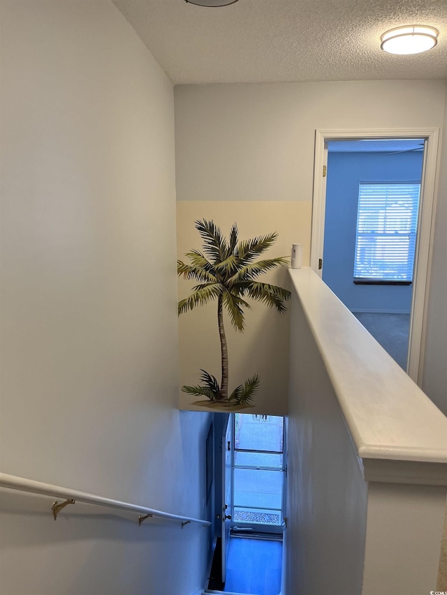 stairs featuring a textured ceiling