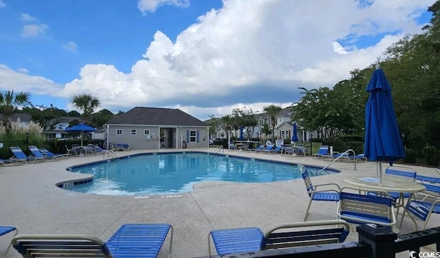 view of swimming pool featuring a patio area and an outbuilding