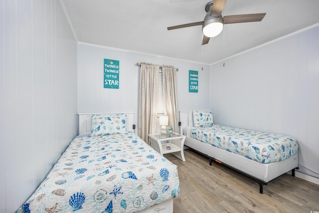 bedroom featuring ornamental molding, a textured ceiling, ceiling fan, and light hardwood / wood-style flooring