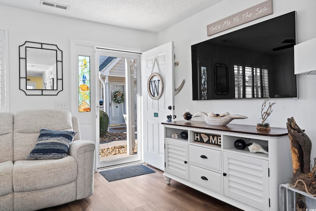 interior space with ceiling fan, dark hardwood / wood-style flooring, white cabinetry, and a textured ceiling