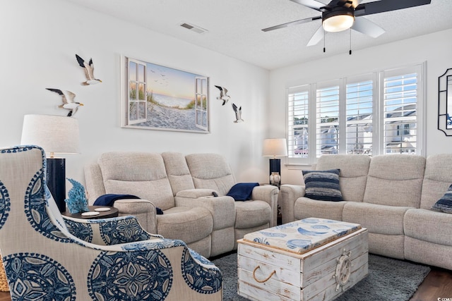 living room featuring a textured ceiling, ceiling fan, and dark hardwood / wood-style floors