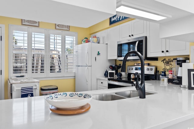 kitchen featuring white cabinetry, a wealth of natural light, sink, and appliances with stainless steel finishes