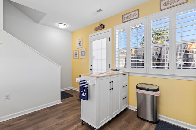 kitchen with dark hardwood / wood-style flooring and white cabinetry