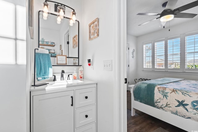 bedroom featuring ceiling fan, sink, dark wood-type flooring, and a textured ceiling