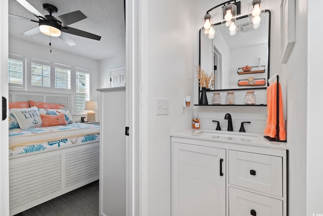 bathroom with vanity, ceiling fan, and a textured ceiling