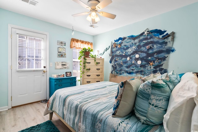 bedroom featuring ceiling fan, light wood-type flooring, and multiple windows