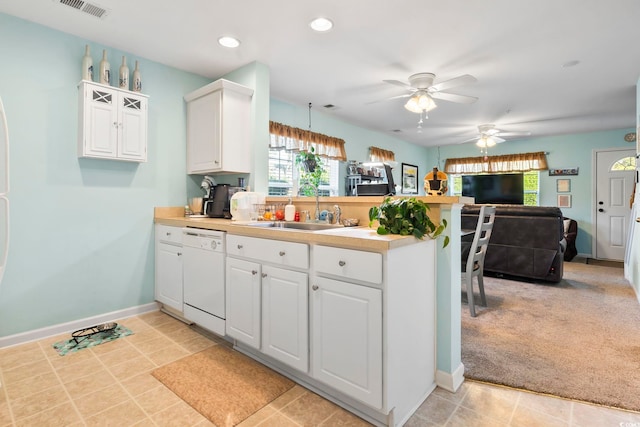 kitchen featuring dishwasher, light carpet, kitchen peninsula, decorative light fixtures, and white cabinetry