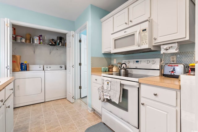 kitchen with white cabinets, decorative backsplash, white appliances, and washing machine and clothes dryer