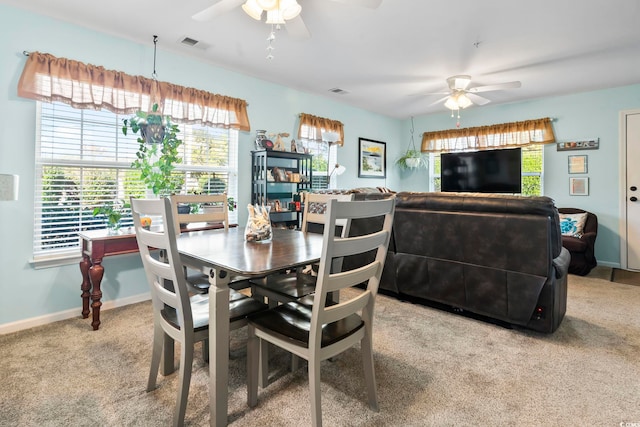 carpeted dining space featuring ceiling fan