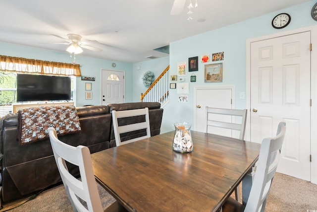 dining space featuring light colored carpet and ceiling fan