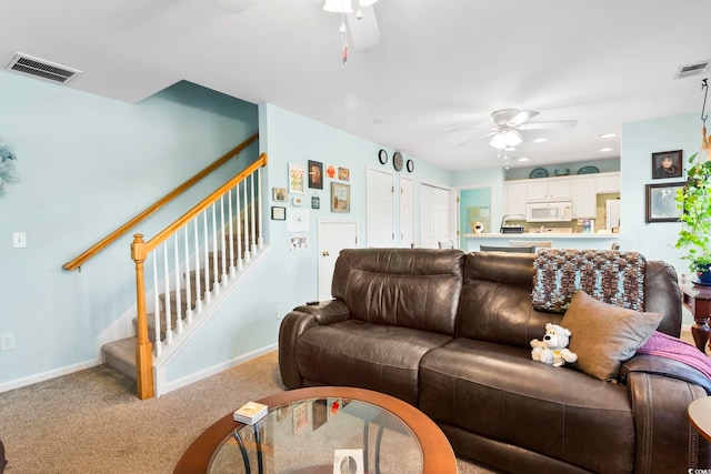 living room featuring carpet flooring and ceiling fan