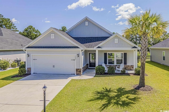 craftsman house featuring covered porch, a garage, and a front yard