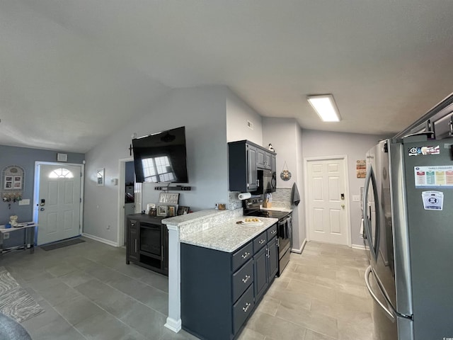 kitchen featuring light tile patterned flooring, appliances with stainless steel finishes, vaulted ceiling, and light stone counters