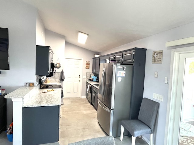 kitchen with stainless steel appliances, light stone counters, kitchen peninsula, vaulted ceiling, and a kitchen bar