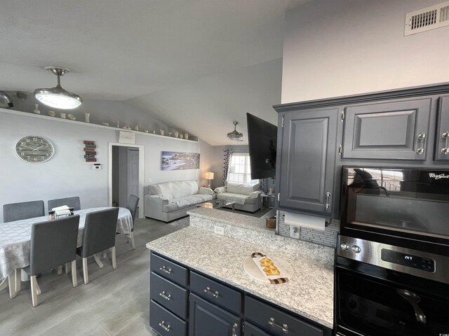 kitchen featuring stainless steel oven and vaulted ceiling