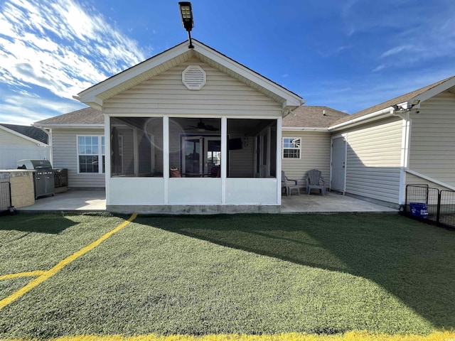 back of property with a sunroom, a yard, and a patio