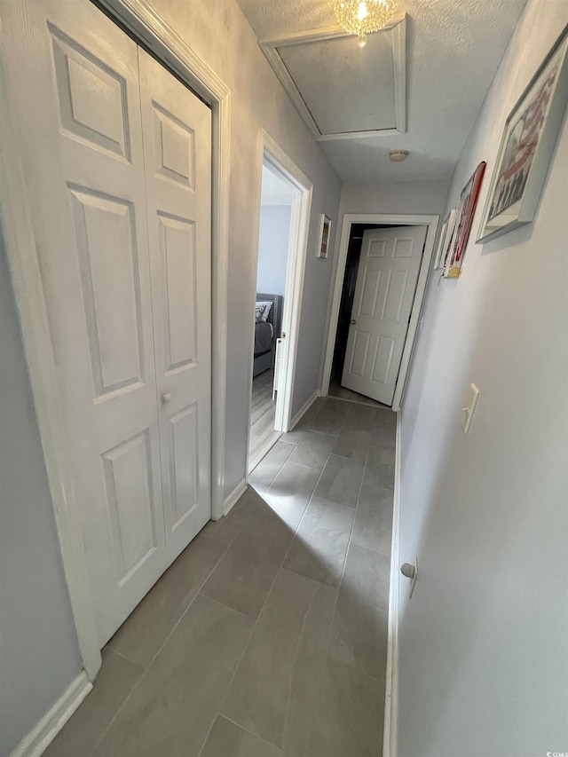 corridor featuring tile patterned floors and a textured ceiling