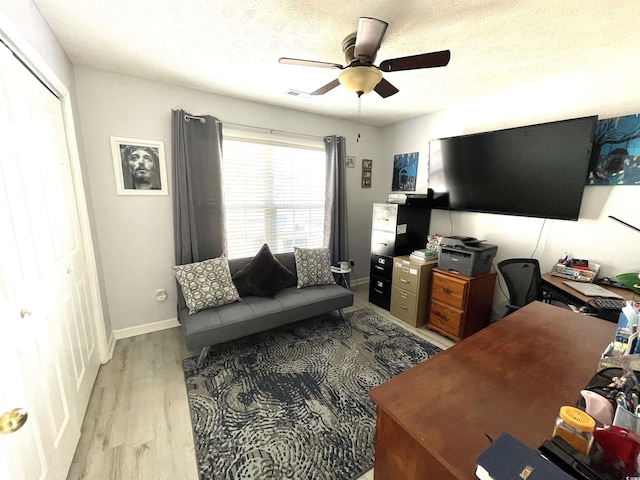 office area featuring a textured ceiling, light hardwood / wood-style floors, and ceiling fan