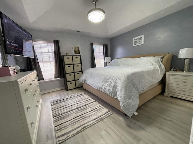 bedroom with lofted ceiling and light wood-type flooring