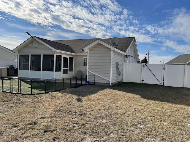 back of property featuring a yard and a sunroom