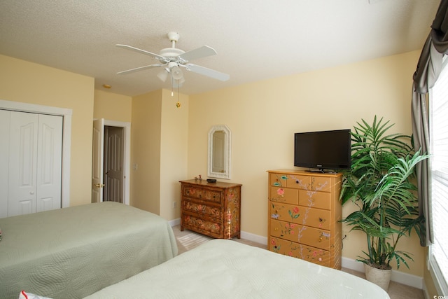 carpeted bedroom featuring ceiling fan and a closet