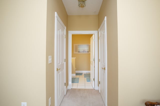 corridor featuring light carpet and a textured ceiling