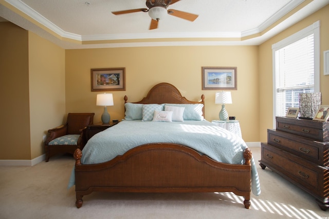 carpeted bedroom featuring ceiling fan, a raised ceiling, and crown molding