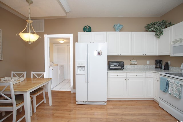 kitchen featuring pendant lighting, white appliances, white cabinets, light hardwood / wood-style flooring, and washing machine and dryer