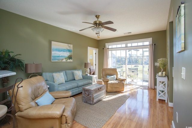 living room with light hardwood / wood-style floors and ceiling fan