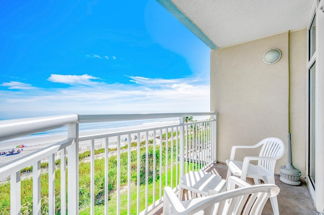 balcony featuring a water view and a beach view