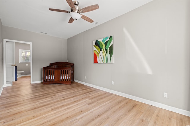 unfurnished bedroom featuring ceiling fan, ensuite bathroom, and light hardwood / wood-style flooring