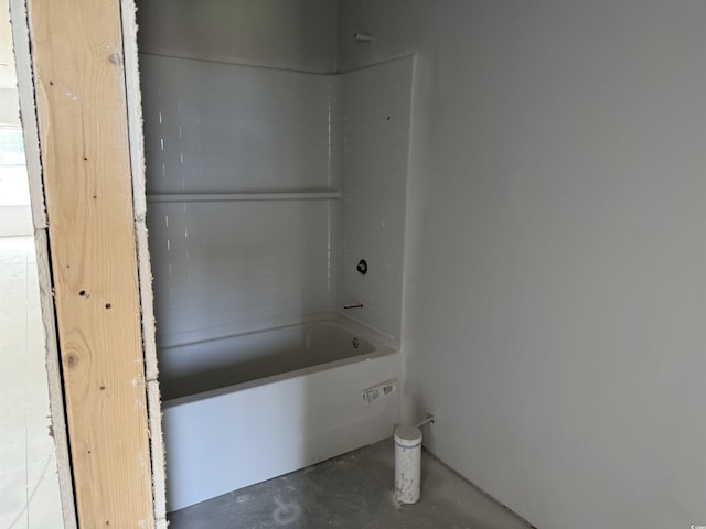 bathroom with concrete floors and a bathtub