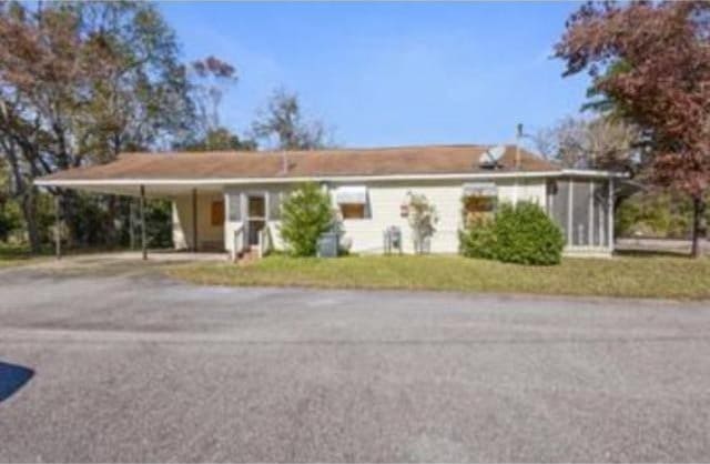 single story home featuring a front yard and a carport