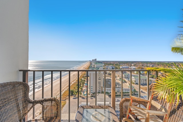 balcony with a water view and a view of the beach