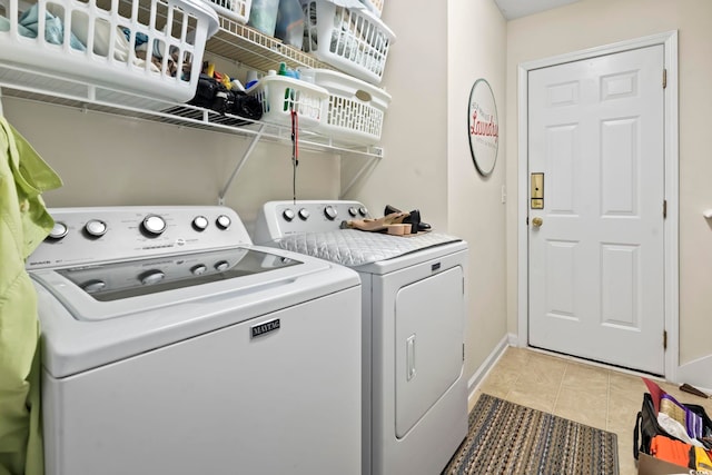 clothes washing area with light tile patterned floors and washing machine and dryer