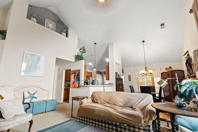 carpeted living room featuring a chandelier and high vaulted ceiling