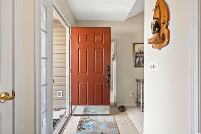 entryway with light tile patterned floors and a textured ceiling