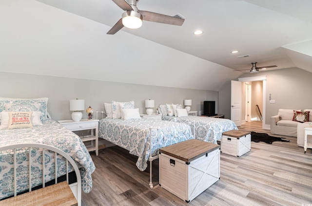 bedroom featuring ceiling fan, light hardwood / wood-style flooring, and lofted ceiling