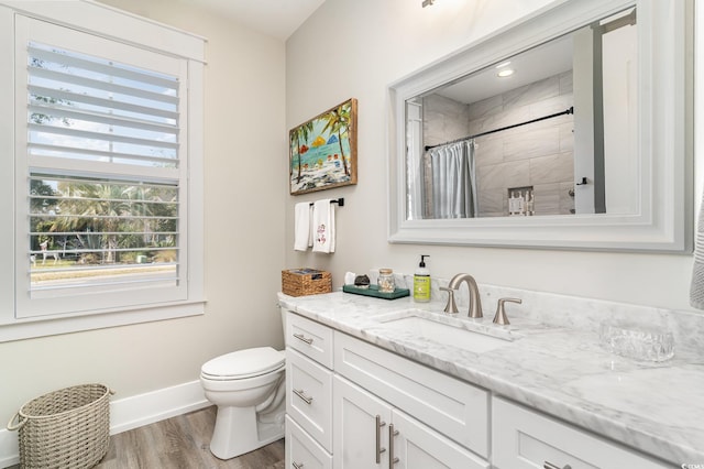 bathroom with wood-type flooring, vanity, toilet, and walk in shower