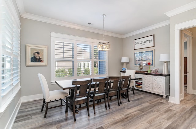 dining room featuring an inviting chandelier, ornamental molding, and hardwood / wood-style flooring