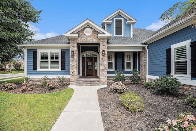 1201 Surf Pointe Dr, North Myrtle Beach, SC 29582 - view of front of home featuring a shingled roof, stone siding, a front yard, and a porch
