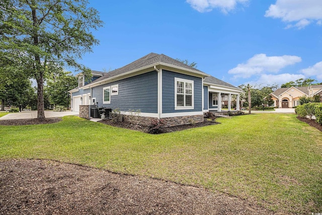 1201 Surf Pointe Dr, North Myrtle Beach, SC 29582 - view of property exterior featuring a yard, a garage, driveway, central AC unit, and roof with shingles