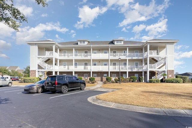 view of building exterior with uncovered parking and stairs