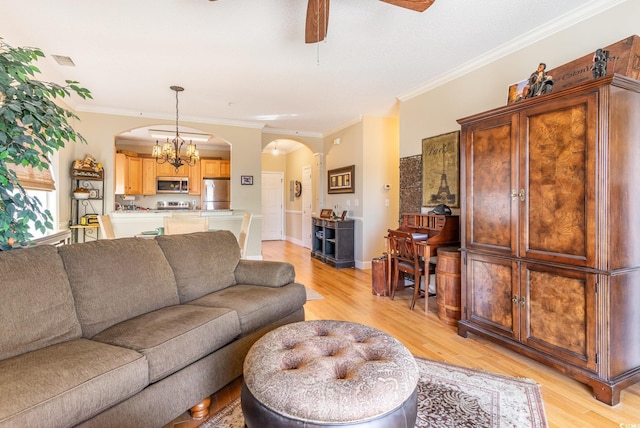 living room with ceiling fan with notable chandelier, arched walkways, light wood-style floors, crown molding, and baseboards