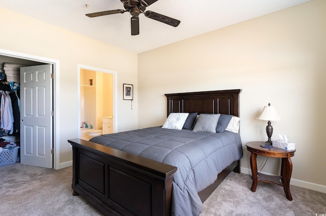 bedroom with ceiling fan, ensuite bath, baseboards, and light carpet