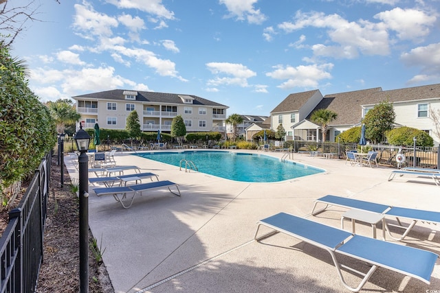 pool featuring a patio area, a residential view, and fence